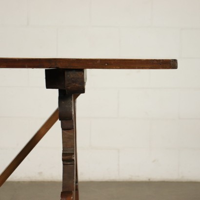 Table à tréteaux réalisée avec des pièces anciennes, soutenues par des pieds ondulés et sculptés, reliés par une traverse, le dessus du cadre porte un tampon d'inventaire sur la face inférieure.