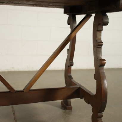 Table à tréteaux réalisée avec des pièces anciennes, soutenues par des pieds ondulés et sculptés, reliés par une traverse, le dessus du cadre porte un tampon d'inventaire sur la face inférieure.
