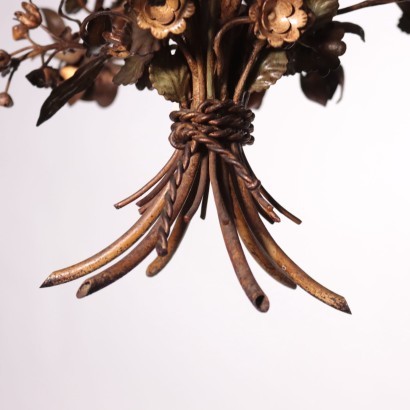 Chandelier in metal and sheet metal worked with floral motifs, gilded and painted.